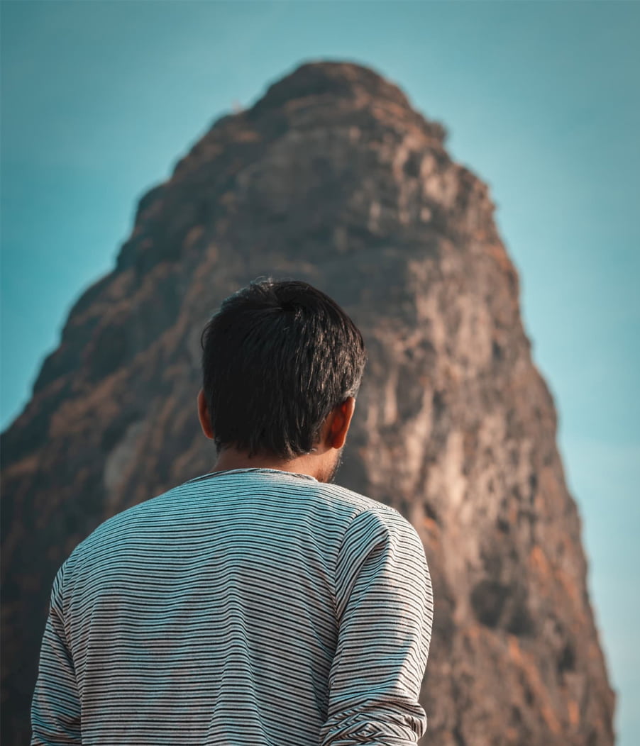 Image of the back of a man's head as he looks up at a tall rock. This image illustrates how hard it can be to work on yourself in individual therapy in Los Angeles, CA. But, meeting with an individual therapist in Los Angeles, CA can really help. | 91006 | 90071