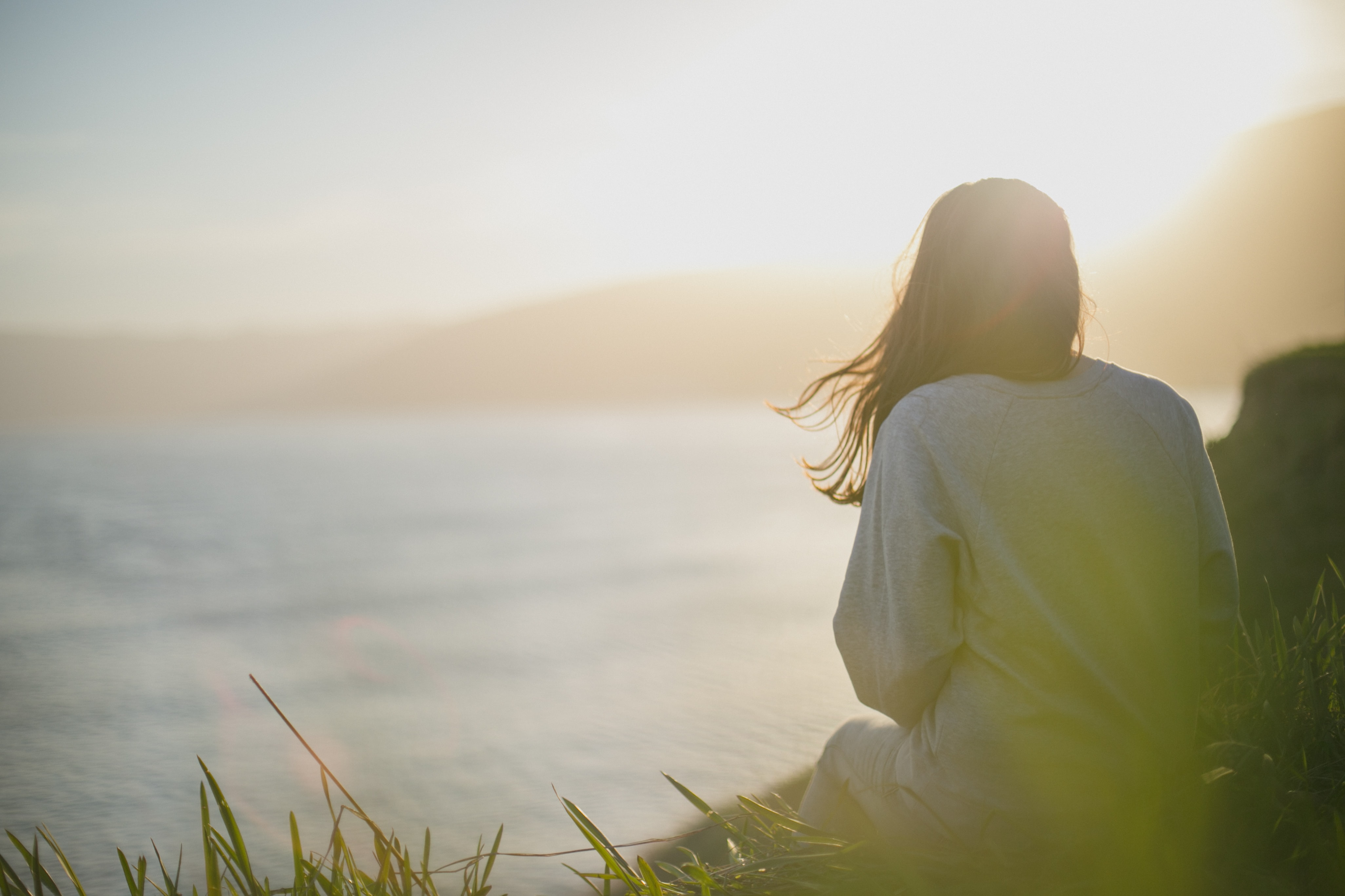 Image of a girl sitting near the beach and looking out at the waves. Working with an HSP therapist in Los Angeles, CA can help you understand yourself. Learn more about HSP treatment and therapy for empaths in Los Angeles, CA. 90404 | 90503