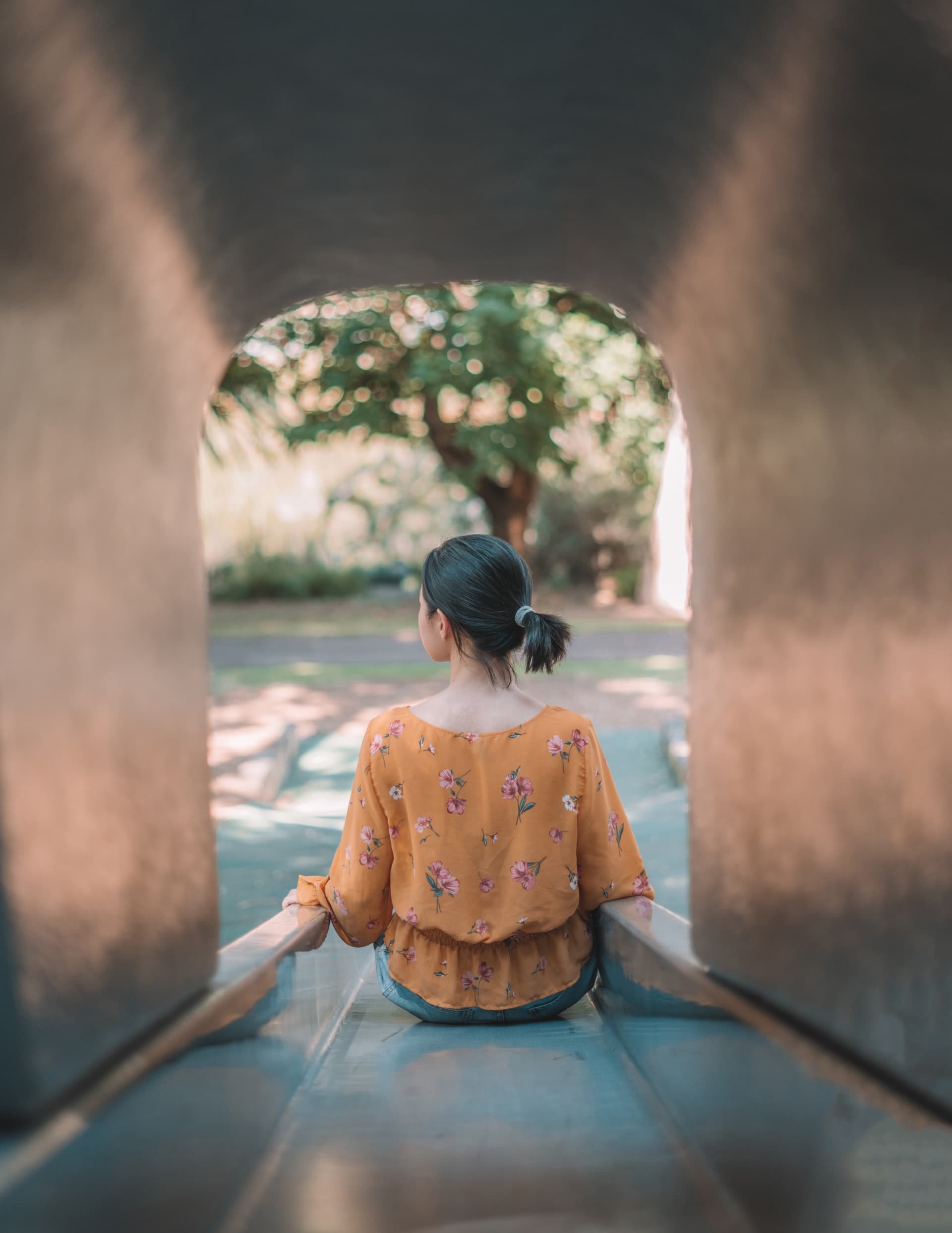 Image of a young Asian woman on a slide in a park. An ADHD therapist in in Los Angeles, CA can help you overcome ADHD symptoms. | 91108 | 91006