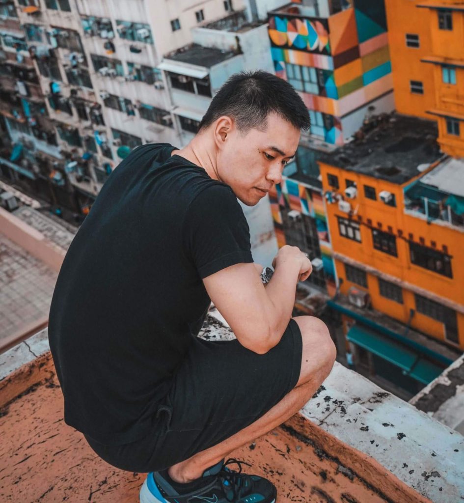 Image of a man crouching over the edge of a city rooftop. This photo illustrates how harmful racial trauma can be without being treated with trauma therapy in Los Angeles, CA. 90504 | 90505