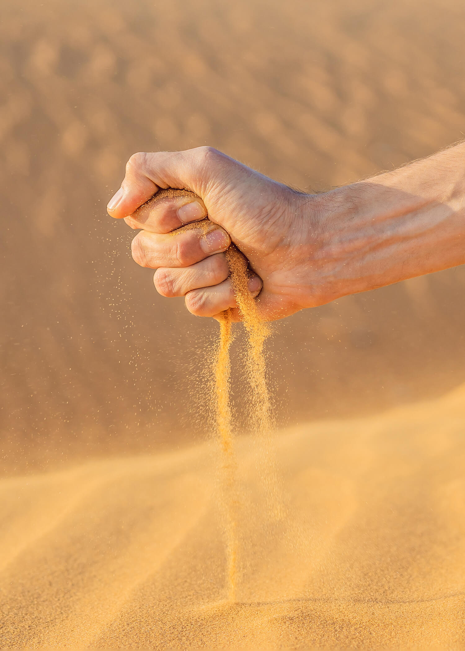 Image of a hand holding sand and releasing it toward the ground. This image illustrates how someone may feel before starting adult ADHD treatment in Los Angeles, CA. Working with an ADHD therapist can really help. | 90504 | 90505