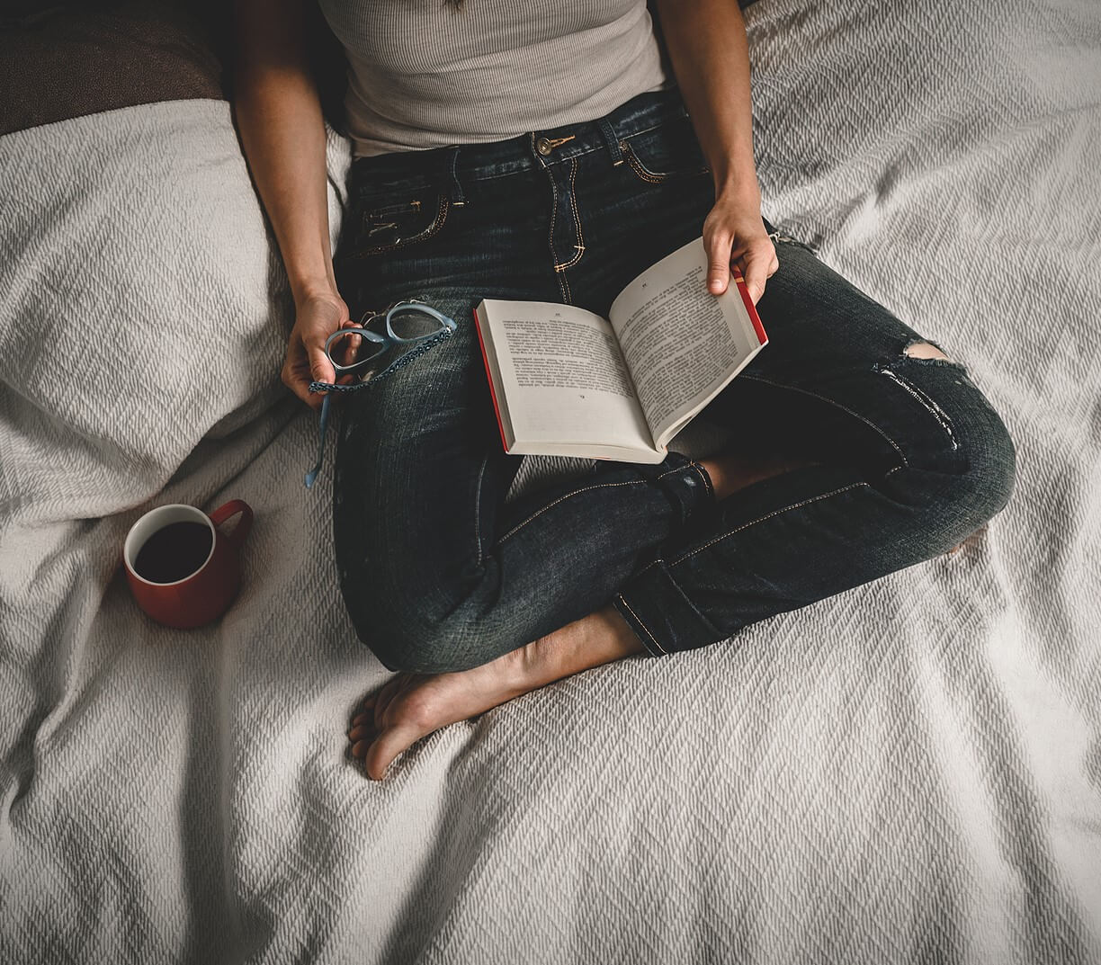 Image of a woman reading and drinking a cup of coffee. This image represents someone who may be in need of adult ADHD treatment, but hasn't started. Reach out to an ADHD therapist in Los Angeles, CA for support. | 91108 | 90232