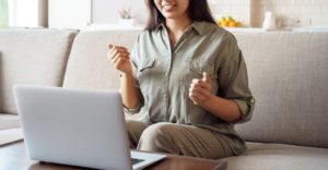 Photo of an Asian American teen sitting on the couch looking at her laptop. With an HSP Therapist in Los Angeles, CA teens can learn how to raise their self-esteem and learn to cope with negative feelings. Click here to learn more!