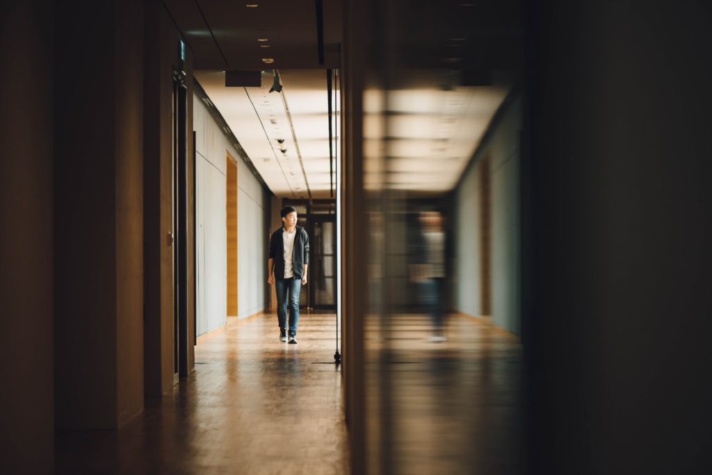 Photo shows a teen boy walking down a hallway. This photo represents how therapy for teens in Los Angeles, CA can help cope with being a highly sensitive person.