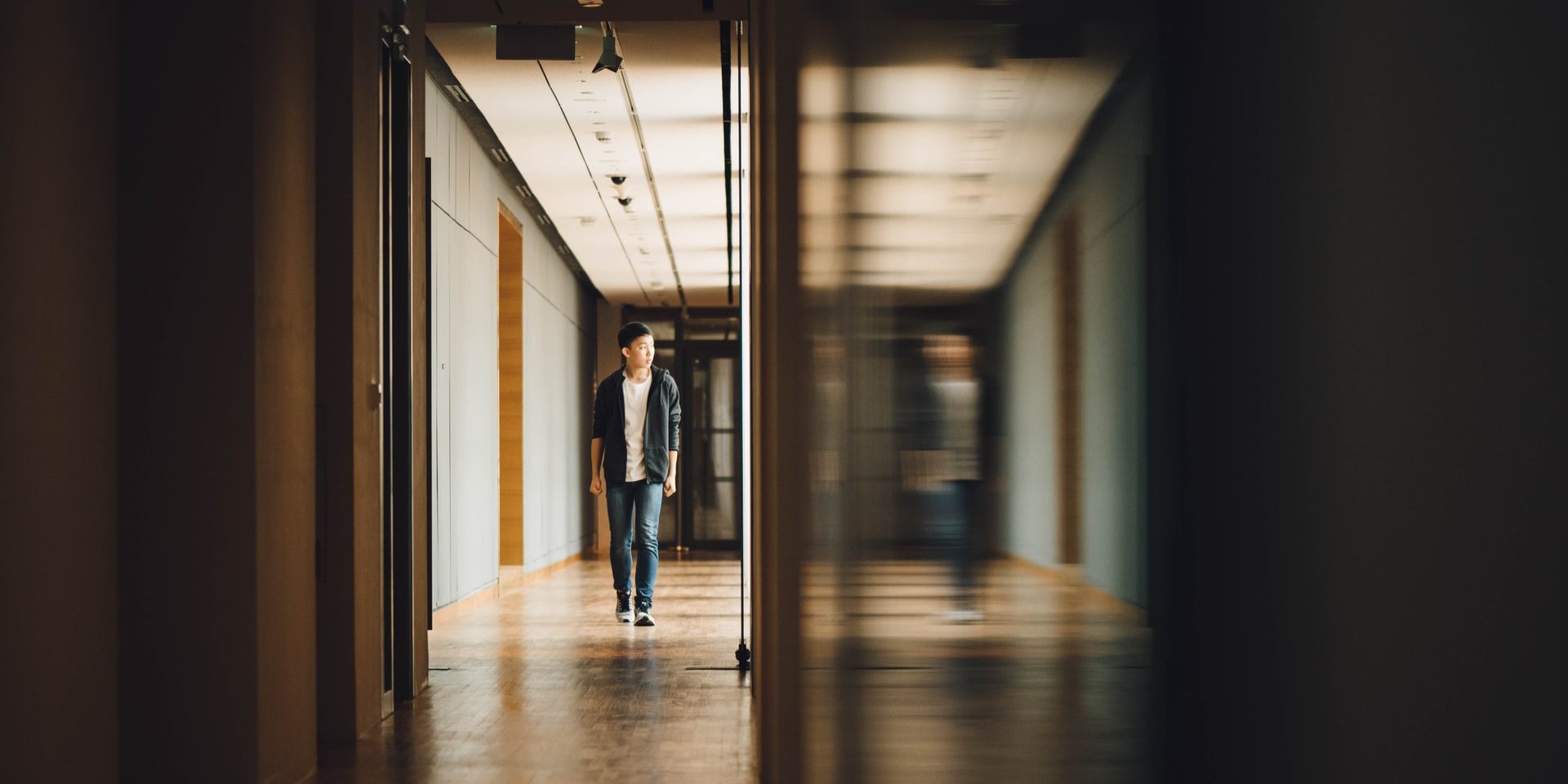 Photo shows a teen boy walking down a hallway. This photo represents how therapy for teens in Los Angeles, CA can help cope with being a highly sensitive person.
