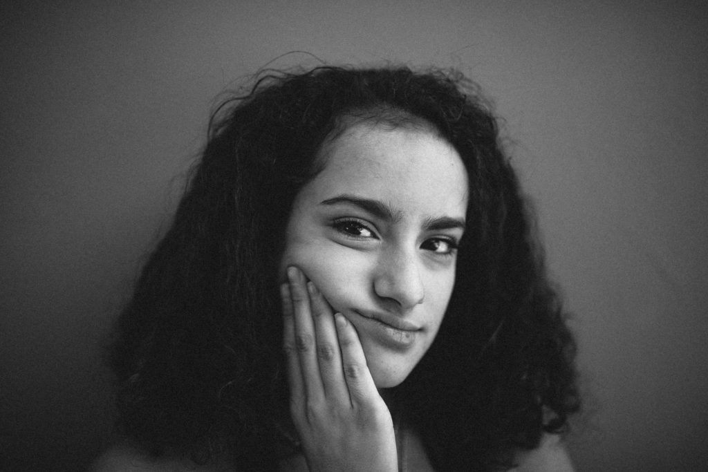 Woman looking sad holding her face and looking at the camera. Adult ADHD therapy and coaching with an asian american therapist in Los Angeles, CA can help you.