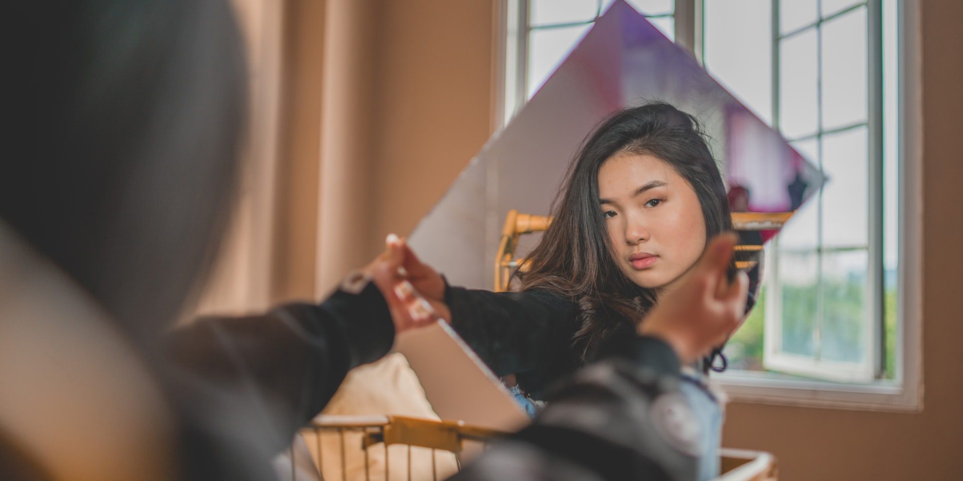 Asian woman looking at her reflection in mirror. (90404, 90503, 91006.) We have therapy for asian women in Los Angeles, CA if you’re struggling with the asian american experience. Asian american therapist in Los Angeles, CA can help you.
