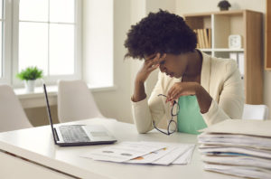 Image of person looking stressed at work. This person could thinking about getting help for work stress management. She could perhaps benefit from burnout treatment in Los Angeles, CA. (91108, 90232).