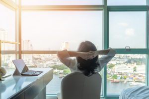 Image of person at office looking relaxed and viewing a skyline. This person looks like they have recently pursued burnout treatment in Los Angeles, CA. Work stress management in Los Angeles, CA could work for you too. Connect with a burnout therapist in Los Angeles, CA. (90404, 90503, 91006).