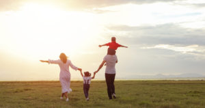This is an image of a family on a field somewhere. This image could depict a family starting culturally sensitive therapy in Los Angeles, CA. Meeting with an Asian American therapist for cultural struggles can help your family. | 91108 | 90232