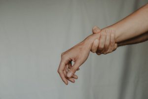 Image of an arm being held by the person's other hand. This image depicts the stress people with trauma are under before starting virtual EMDR in California. 91006 | 90071