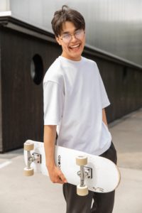 Asian American teen male smiling representing the positive benefits of having an Asian American mental health therapist in the city of of Los Angeles, California.