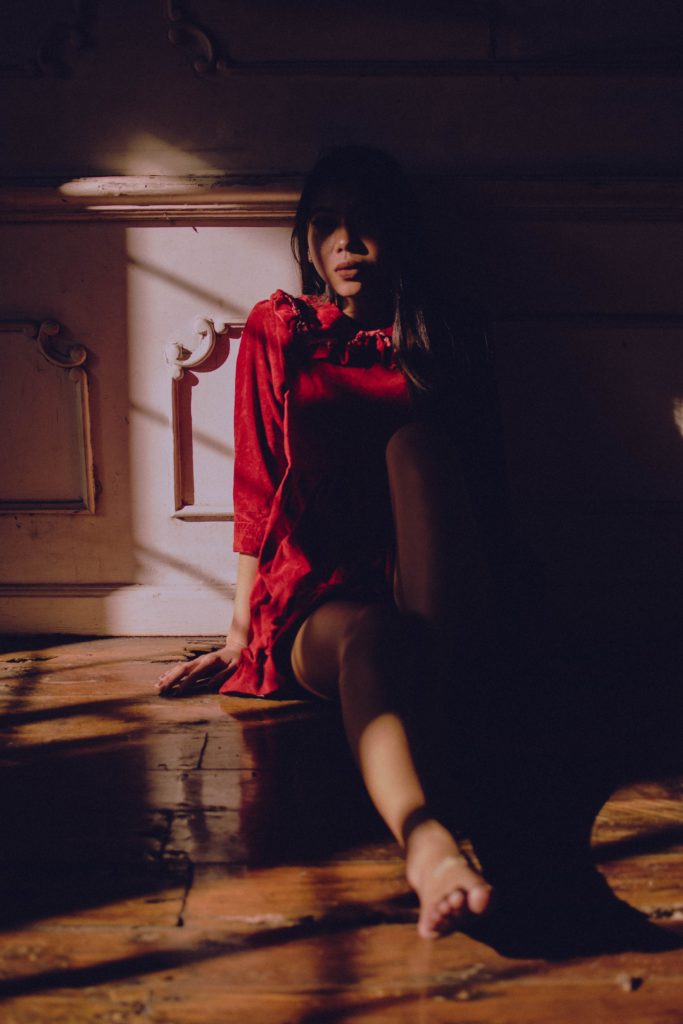 A person sitting in the shadows of a building representing how important it is for Asian women to receive therapy in the Los Angeles, California area.