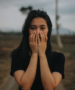 An Asian woman covering part of her face representing how Asian and Asian American women have been dismissed and invalidated for years, especially in Los Angeles, California.