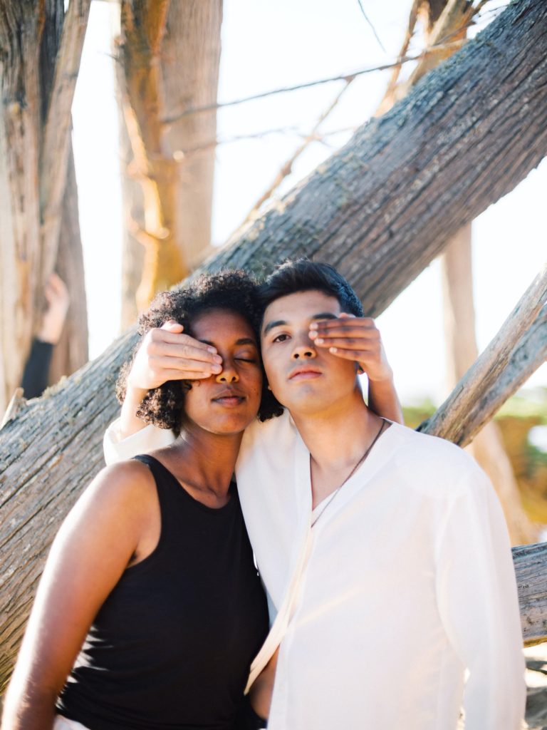 Photo of man and a woman standing beside each other outside covering each others eyes. Want to find a therapist who understands your culture? With culturally sensitive therapy in New York you can start healing with someone who understands your background.