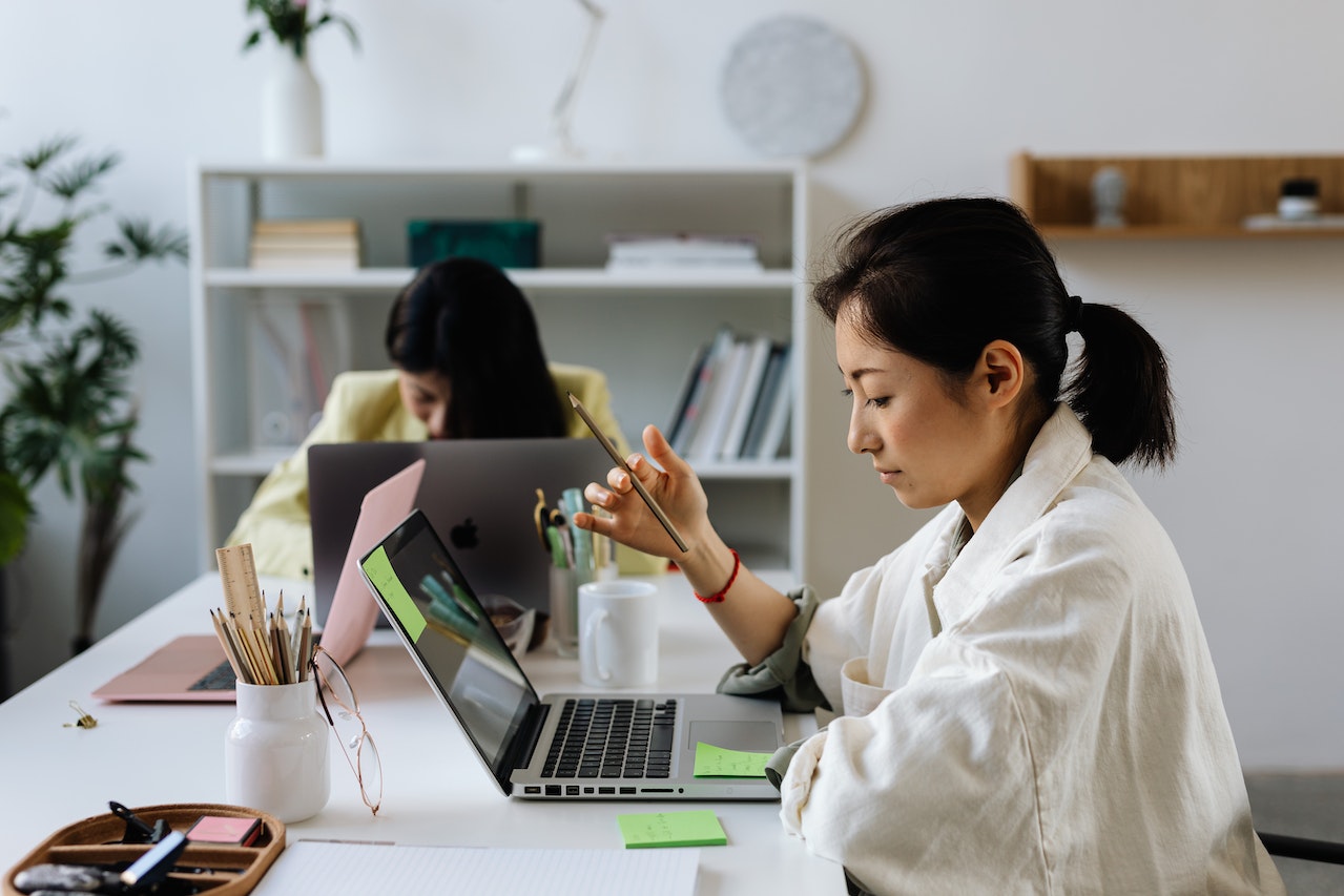 A woman focuses on her laptop while holding a pencil in her hand. This could represent overcoming the struggles of adult ADHD in Los Angeles, CA that an Asian American therapist can offer support with overcoming. Learn more about adult ADHD therapy in Los Angeles, CA, and other services.