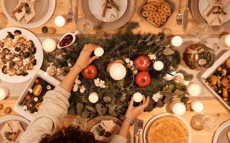 A top-down view of a dinner table with holiday decor and dishes. This could symbolize the bonds cultivated after navigating holiday stress. Learn more about the support a stress management therapist in Los Angeles, CA can offer by searching for an Asian therapist in New York or LA with Yellow Chair Collective.