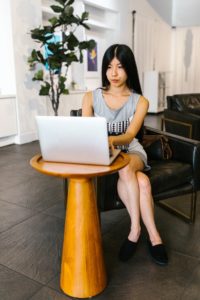 A woman sits at a desk with her laptop. Learn how adult ADHD therapy in Los Angeles, CA can offer support from where is best for you. Online therapy in California can offer remote support including adult ADHD therapy and coaching in Los Angeles, CA. 
