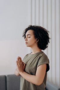 A woman with earbuds stands while practicing deep breathing. This could represent a mindfulness technique for coping with adult ADHD in Los Angeles, CA. Learn more about ADHD treatment in Los Angeles, CA, and other services including couples therapy and marriage counseling in Los Angeles, CA.
