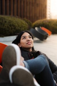 A young adult looks up into the sky with a smile while sitting in a chair. Learn how an ADHD therapist in Los Angeles, CA can offer support with understanding the effects of adult ADHD in Los Angeles, CA. Learn more about adult ADHD therapy and coaching today.
