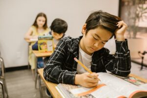 An Asian American student reads a textbook while scratching their head. Learn how an ADHD therapist in Los Angeles, CA can help overcome academic pressures faced by Asian Americans, which can lead them to compensate for ADHD. Search “adult adhd therapy in coaching” today.
