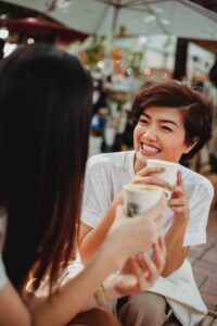 Two friends smile at one another while drinking coffee and talking. This could represent the support that an EMDR therapist in Los Angeles, CA can offer from home via virtual EMDR therapy. Search “EMDR for anxiety in Los Angeles, CA” today to learn more.
