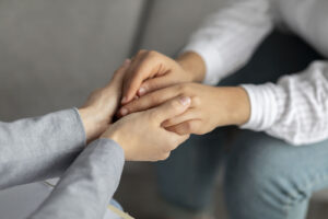 A close up of a person holding the hands of another, representing the support therapy for Asian women in Los Angeles, CA can offer. Learn more about therapy for Asian women by contacting an Asian therapist in New York or CA today.
