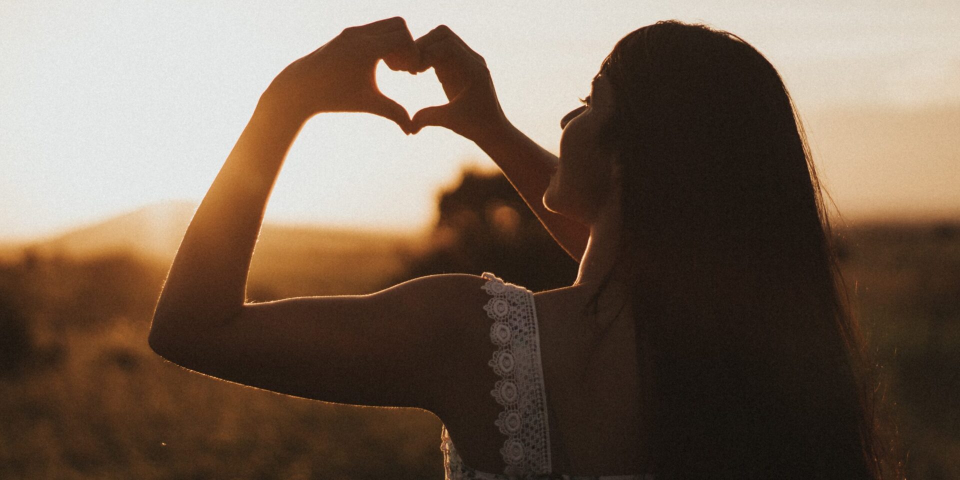 A woman holds her hands out in a heart shape against the setting sun. Contact an empath therapist in Los Angeles, CA for support with empath therapy in Los Angeles, CA. Search for “empath therapist near me” to learn more.