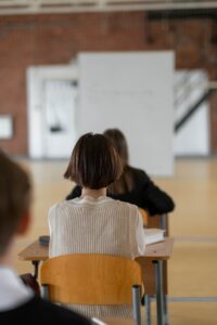 A child sits at a desk for testing in a school gym. Learn how a trauma therapist in Los Angeles, CA can offer support with children with ADHD and adult ADHD therapy in Los Angeles, CA. Search for adult adhd therapy and coaching today.
