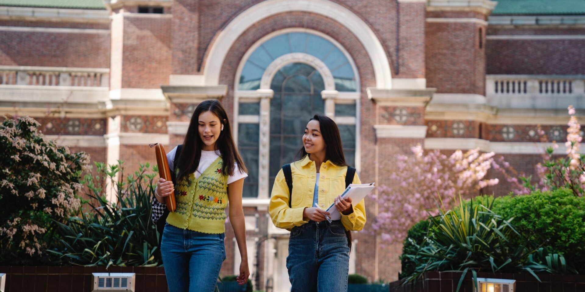 Two Asian American students walk away from a buliding while talking. Learn how therapy for teens in Los Angeles, CA can help your teen and their unique mental health concerns. Contact an Asian American therapist in Los Angeles, CA or Asian therapist in New York for support.