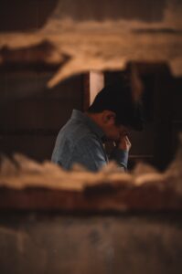 A close-up of a hole in a wall with a person crying on the other side. This could represent the emotional pain of depression an Asian American therapist can address. Learn more about Asian American therapy in New York and other services by searching for Asian American therapy near me. 
