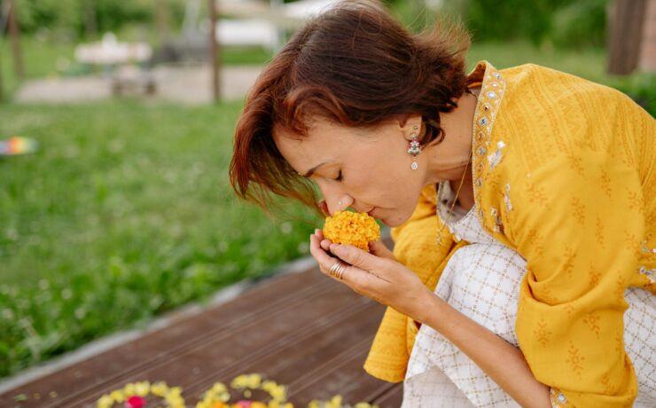 A woman crouched down smelling a yellow flower. Learn how a South Asian support group can help. Search for therapy for South Asian women in Los Angeles, CA, and NYC to learn more about therapy today.