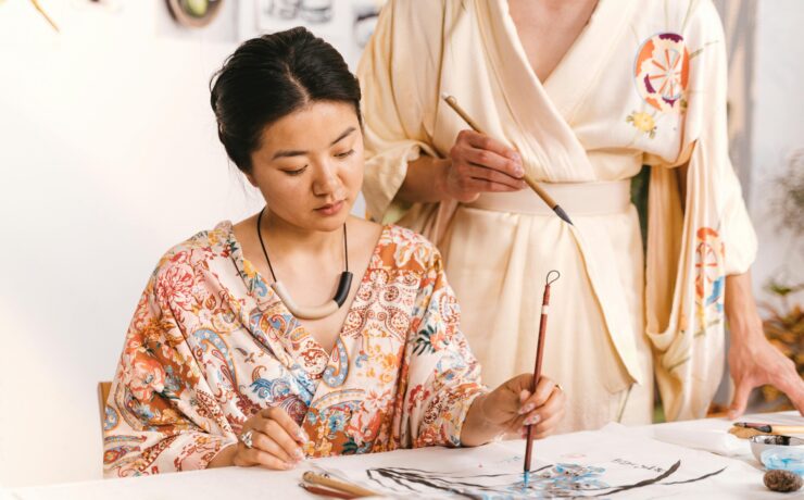 An Asian American woman sits and paints while sitting at a table. Learn how an Asian American therapist can offer support with addressing anxiety. Search for anxiety treatment in Los Angeles, CA or online anxiety treatment in California today.
