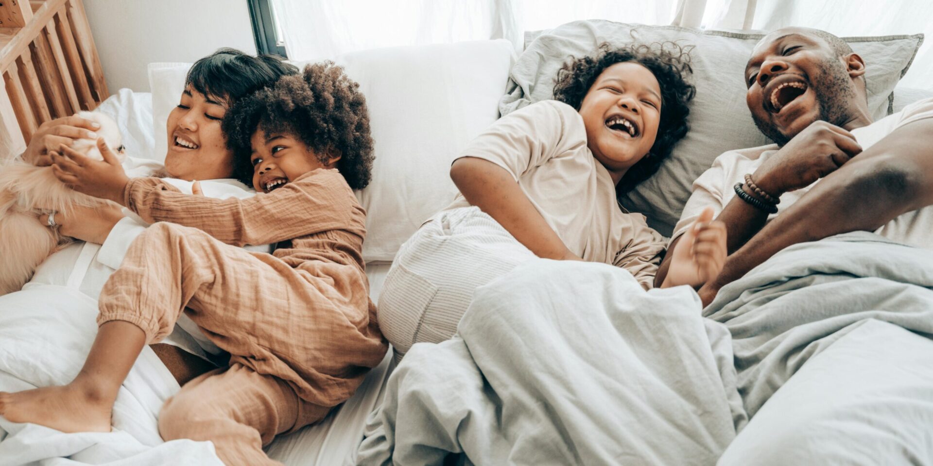 A family smiles while laughing and laying together in bed. Learn how an Asian therapist in Los Angeles, CA can offer support with neurodiversity. Search for a neurodiversity-affirming therapist in Los Angeles, CA to learn how they can offer online therapy in Los Angeles, CA or New York.