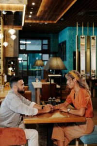 A couple hold hands while sitting across from each other at a restaurant. Learn more about the help that individual therapy in Los Angeles, CA can offer support with dating by searching for online couples therapy in California. An Asian therapist in California can offer support today.
