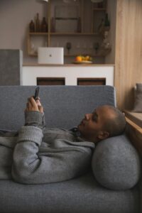 A man lays on a couch while texting on their phone. Learn how individual therapy in Los Angeles, CA can help you learn more about dating and how an online Asian therapist in New York can offer support. Search for culturally sensitive therapy in New York to learn more. 

