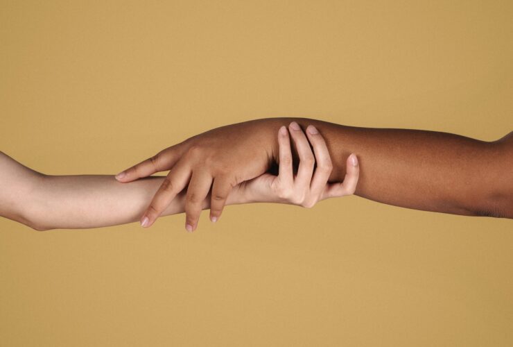 Two hands of different skin tones holding each other. Learn how a neurodiversity-affirming therapist can help ADHD couples today. Search online for ADHD couples therapists in Los Angeles and New York for more information.