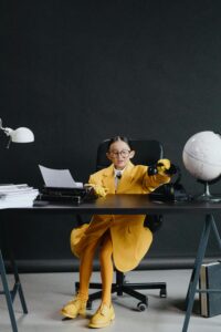 A child in an oversized jacket sits at an office desk while appearing to work. This could represent child parentification and emotional immature parents. This could represent the effects of stress that an Asian American therapist in Los Angeles can address with multicultural therapy in Los Angeles, CA. Search for culturally sensitive therapy in New York to learn more.
