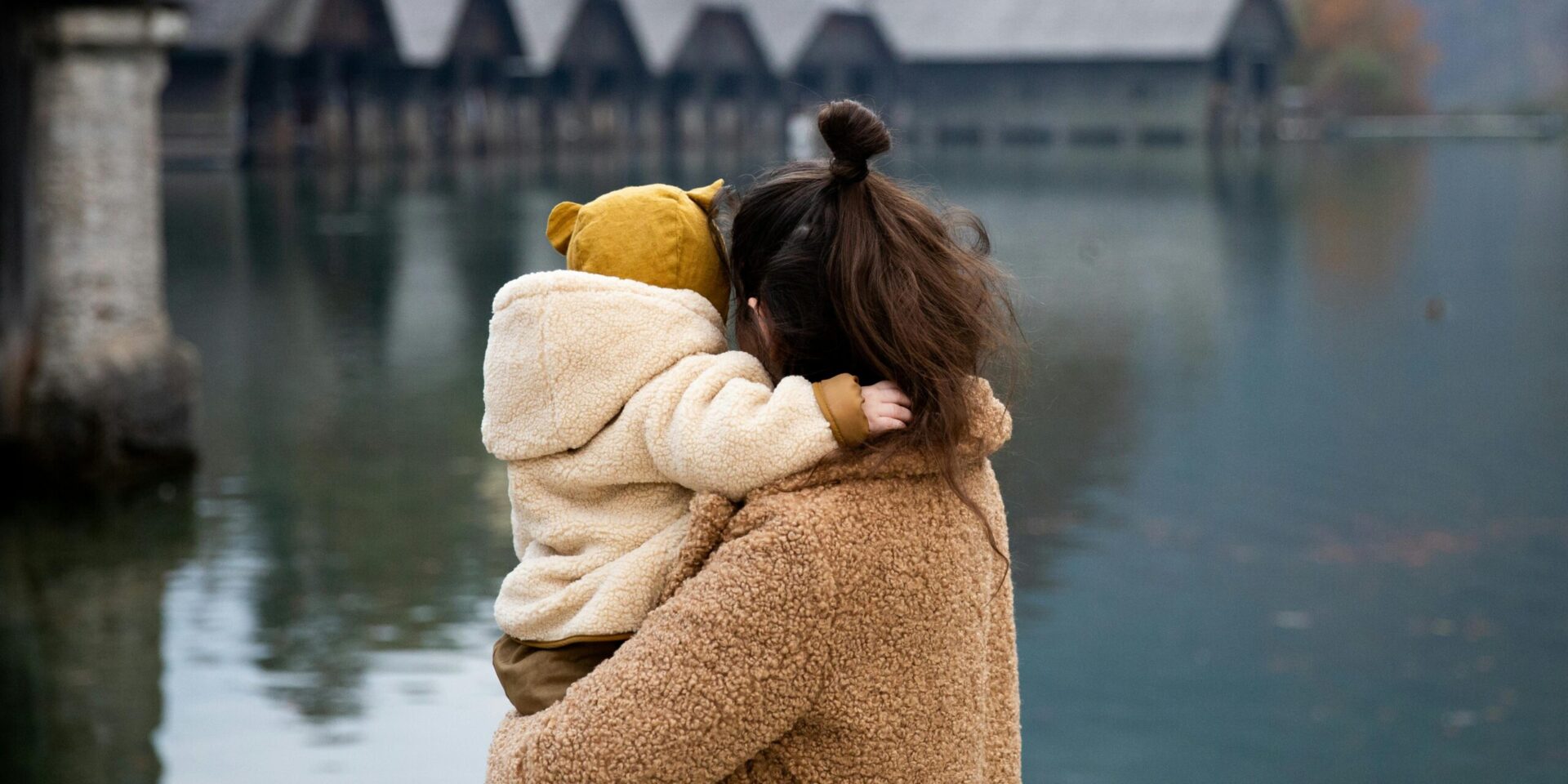 A mother holds her child in her arms while looking out at an open lake. Learn more about highly sensitive person treatment in Los Angeles, CA, and how an online therapist in New York can offer support. Search for a stress management therapist in Los Angeles, CA to learn more.