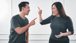 A couple argue while gesturing with their hands. This could represent the stress of anger and heightened emotions that online couples therapy in California can help you address. Learn more about how an Asian therapist in New York or California can offer support by searching for Asian American therapy near me today. 
