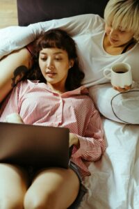 A couple cuddle together while focusing on a laptop as one partner types. Learn how online couples therapy in California can offer support by contacting an Asian American therapist in California today. Search for couples therapy and marriage counseling in Los Angeles, CA today.
