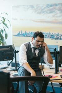 A man sits on a table while on the phone at their work desk. This could represent how displacing anger could affect your relationships. Learn more about how an Asian therapist in New York or California can offer support. Search for couples therapy and marriage counseling in Los Angeles, CA today.
