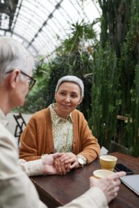 An older couple hold hands while enjoying coffee at a table. Learn how online couples therapy in California can offer support for relationships by contacting an online therapist in Los Angeles, CA. Search for how marriage counseling in Los Angeles, CA can offer support today.
