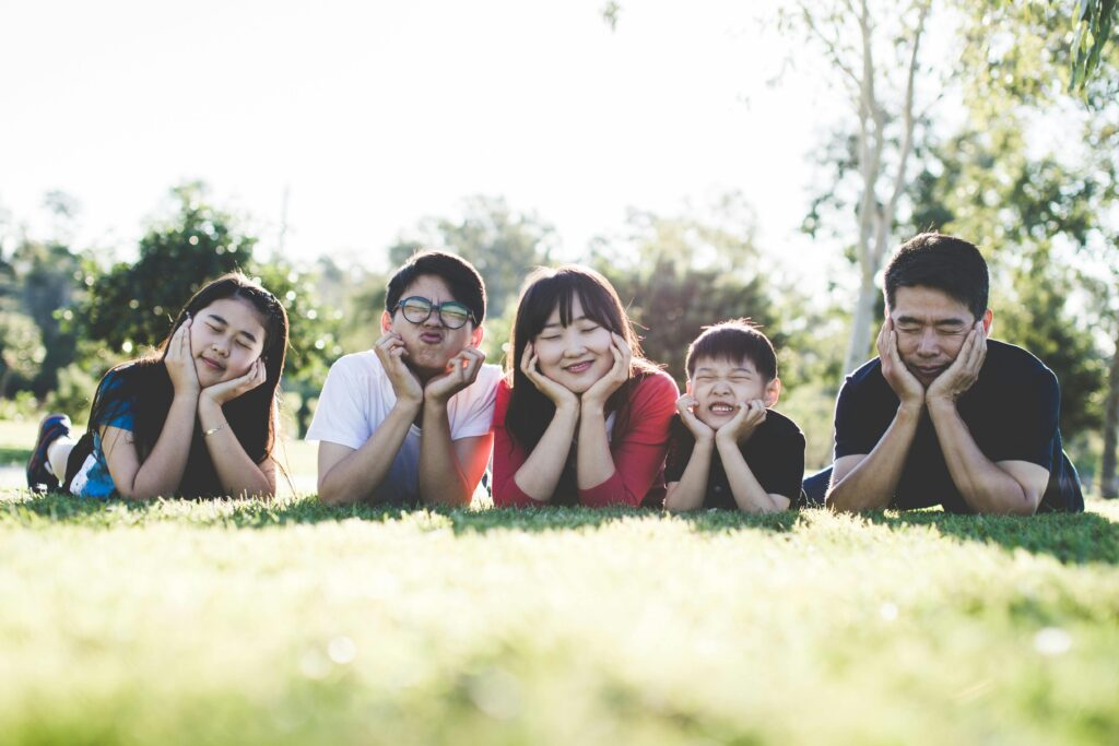 A group of teens lay in the grass while smiling and posing for the camera. This could represent the struggles of ADHD that an ADHD therapist in Los Angeles, CA can help you address. Learn more about therapy for teens in Los Angeles, CA and how ADHD treatment in Los Anglees, CA can help today!