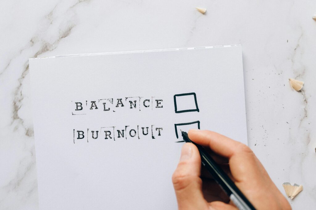 A close up of a hand holding a pen over a checkbox next to the word burnout. Learn how to find balance with a burnout therapist in Los Angeles, CA by searching for individual therapy in Los Angeles, CA. You can get in contact with an Asian American therapist near me today.