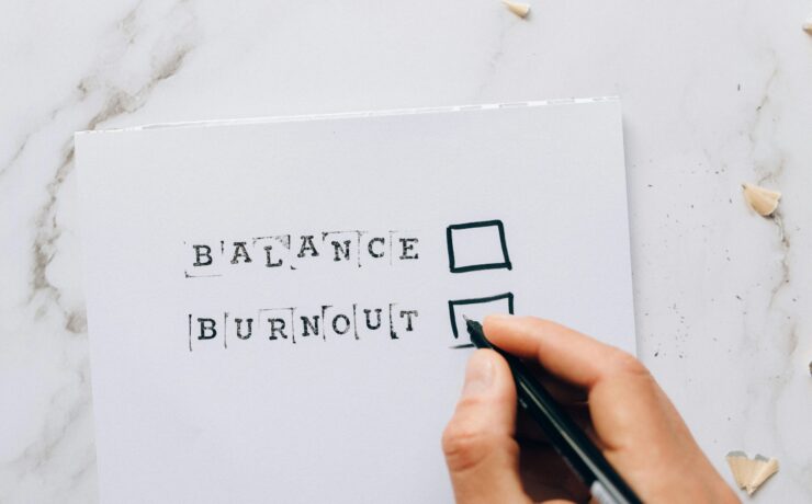 A close up of a hand holding a pen over a checkbox next to the word burnout. Learn how to find balance with a burnout therapist in Los Angeles, CA by searching for individual therapy in Los Angeles, CA. You can get in contact with an Asian American therapist near me today.