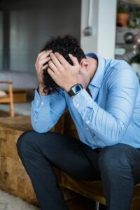 A young adult holds their head while sitting with a defeated stance. Learn how a burnout therapist in Los Angeles, CA can offer support with addressing work burnout. Contact a burnout therapist in Los Angeles, CA for support via online anxiety treatment in California and other services.
