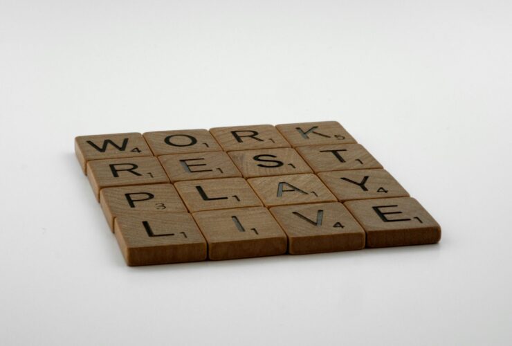 Four rows of wooden squares with printed letters that read, from top to bottom, "Work, Rest, Play, Live."