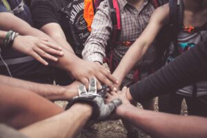 A close up of a group of people standing in a circle and stacking their hands. This could represent the support that an Asian American therpaist in California can offer for recognizing the importance of community. Search for multicultural therapy in Los Angeles, CA to get in contact with a culturally sensitive therapist new york
