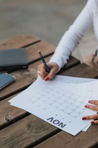 a woman writes in a monthly planner